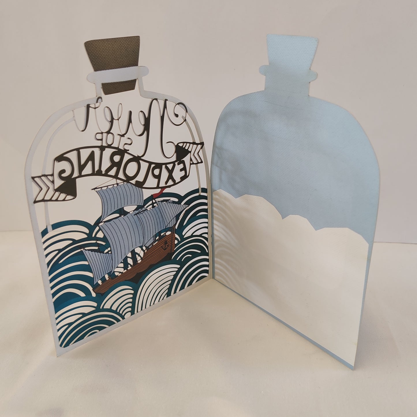 Never stop exploring pierced out greeting card. Ship in a bottle design