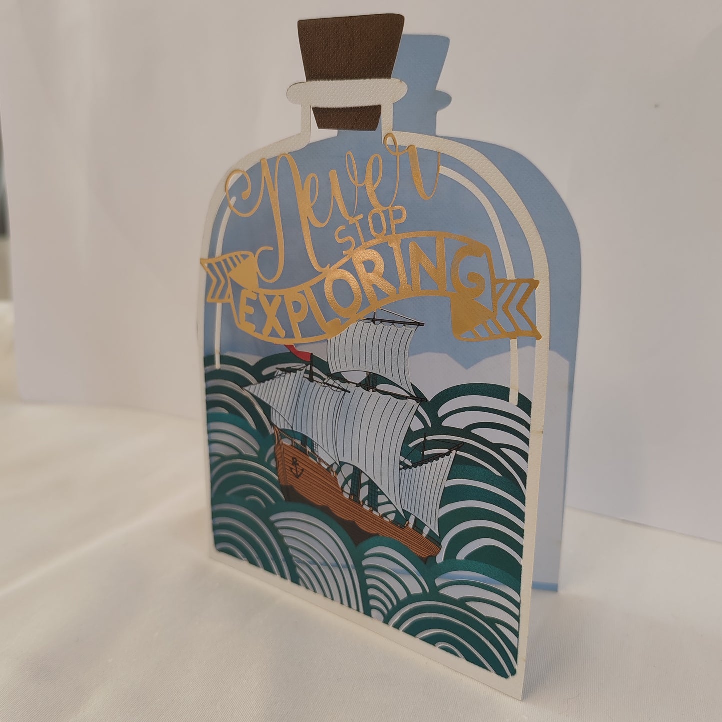 Never stop exploring pierced out greeting card. Ship in a bottle design