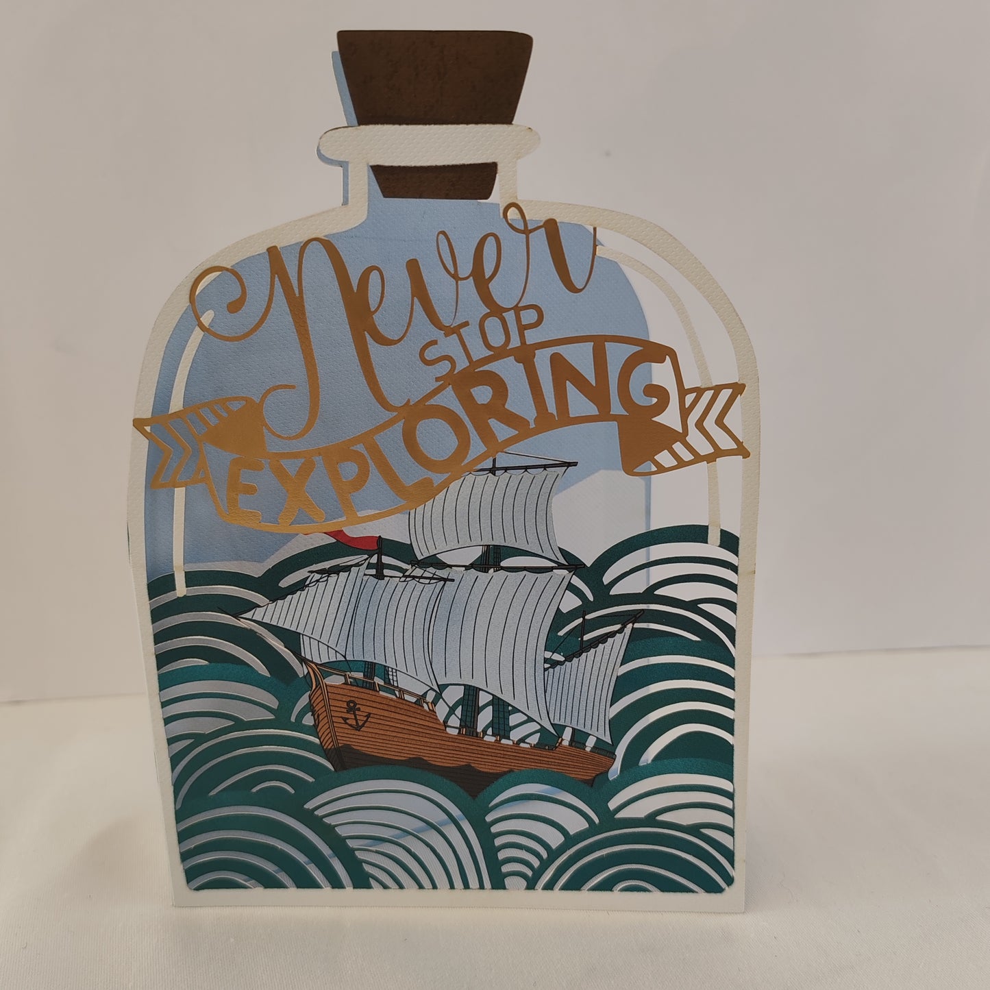 Never stop exploring pierced out greeting card. Ship in a bottle design