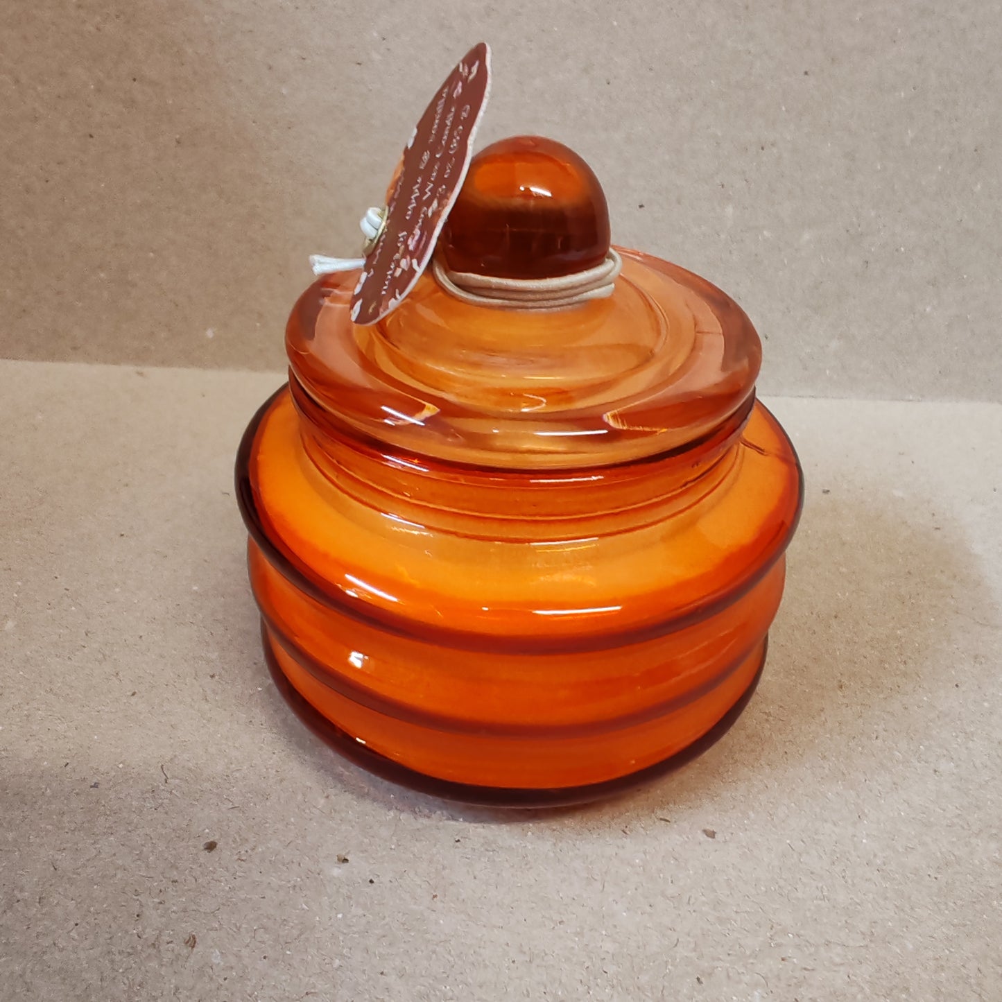 Scented candle in a orange glass jar. Pumpkin spice