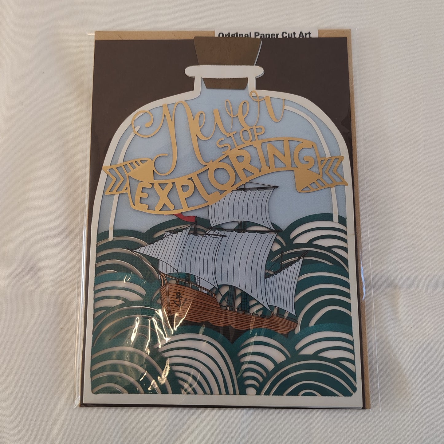 Never stop exploring pierced out greeting card. Ship in a bottle design