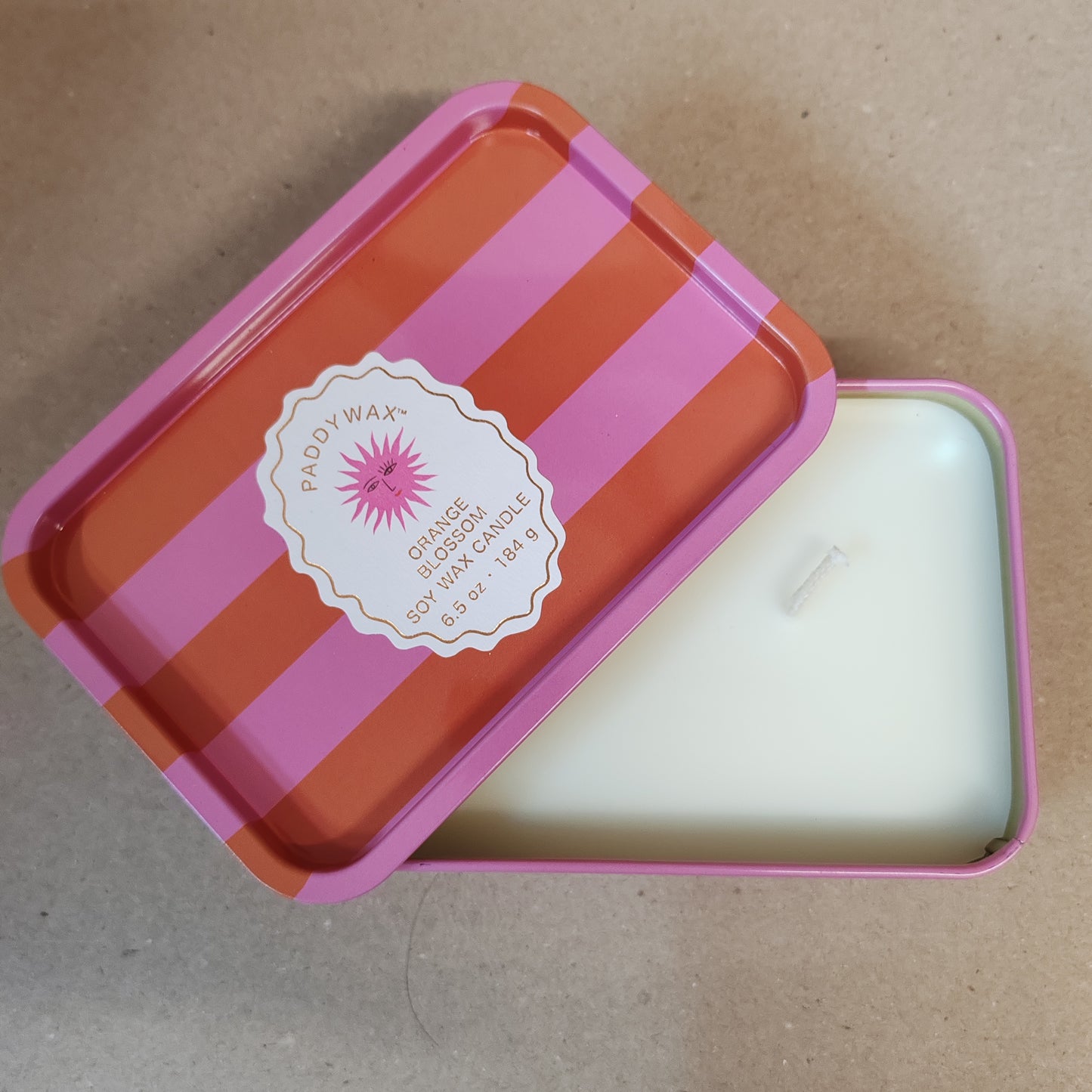 Scented candle in a stripey decorative tin. Scent of orange blossom