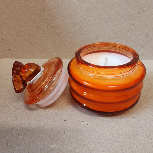 Scented candle in a orange glass jar. Pumpkin spice