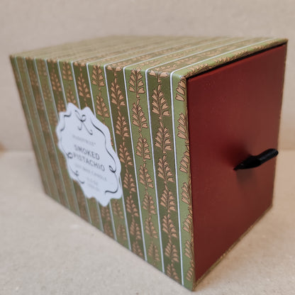 Cherie 5.5oz scented candle in porcelain lides pot with drawer packaging. Scent of Smoked Pistachio.