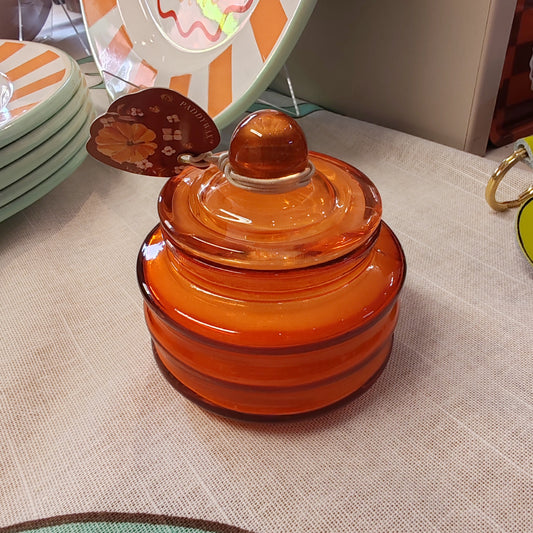 Scented candle in a orange glass jar. Pumpkin spice