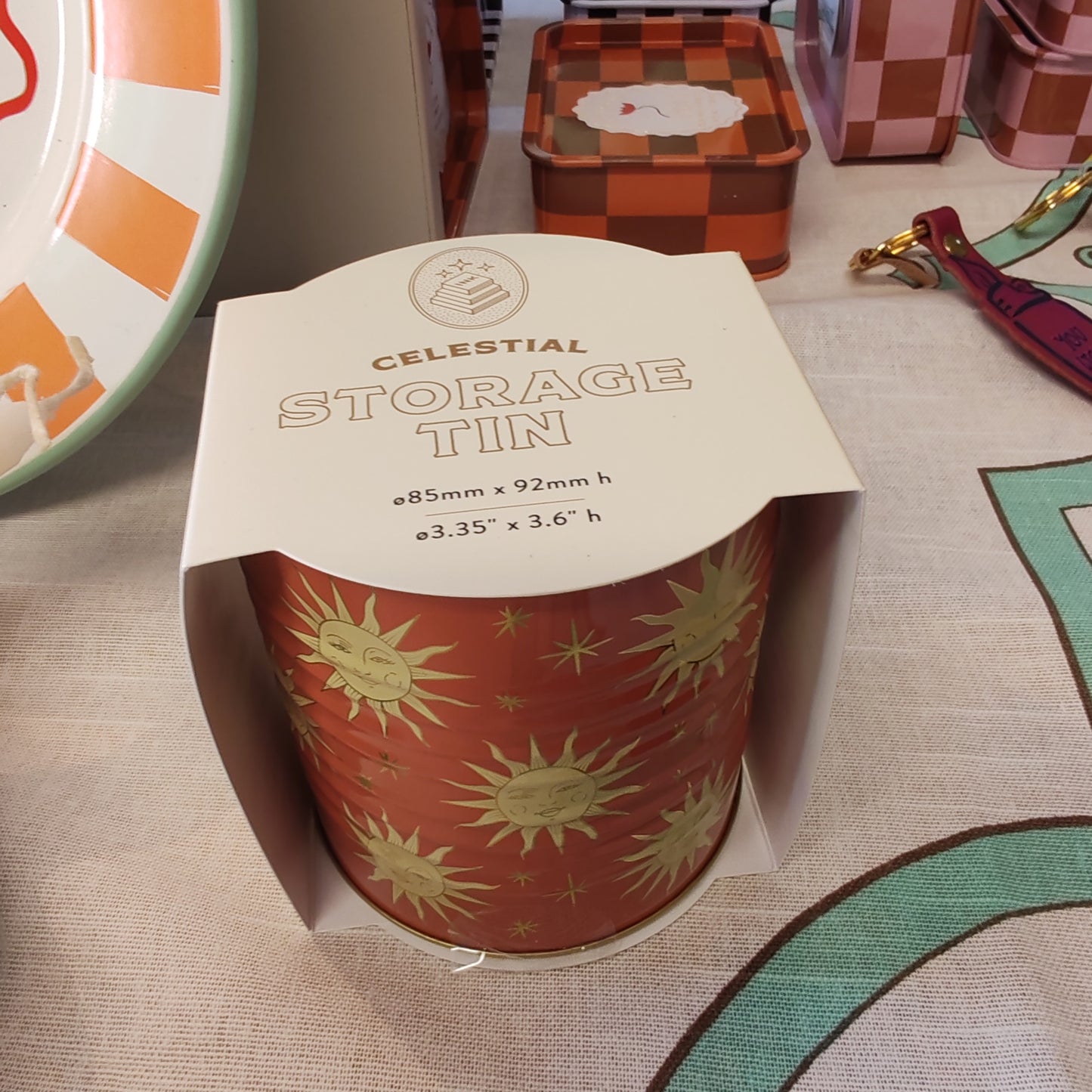 Celestial storage tin decorated with the sun faces.